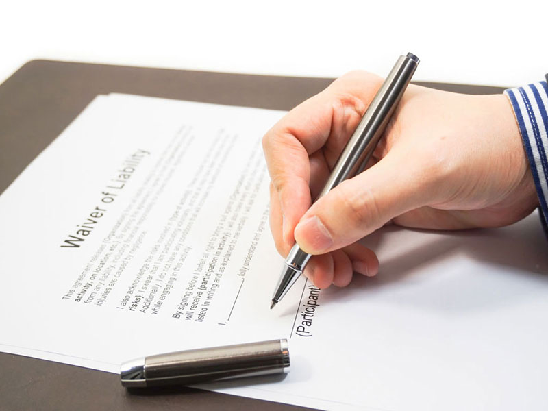 Photo Displaying a Pen-in-Hand Signing a Lien Waiver